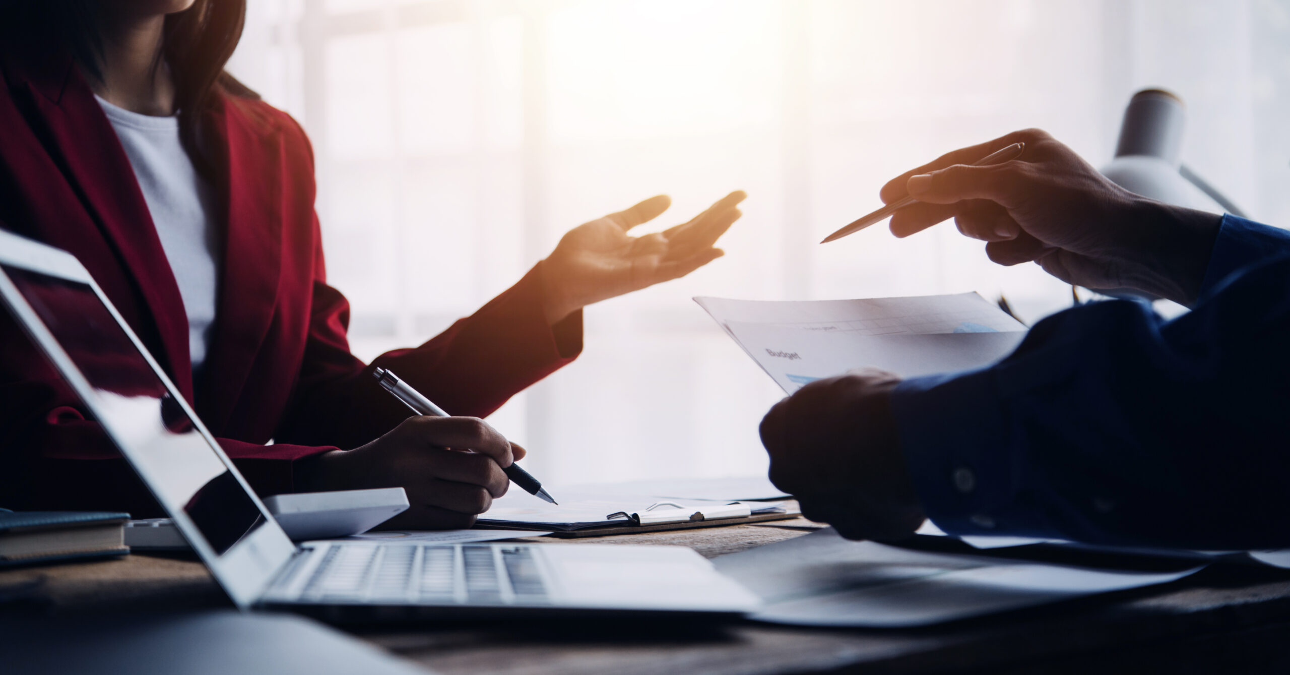 Financial analysts analyze business financial reports on a digital tablet planning investment project during a discussion at a meeting of corporate showing the results of their successful teamwork.