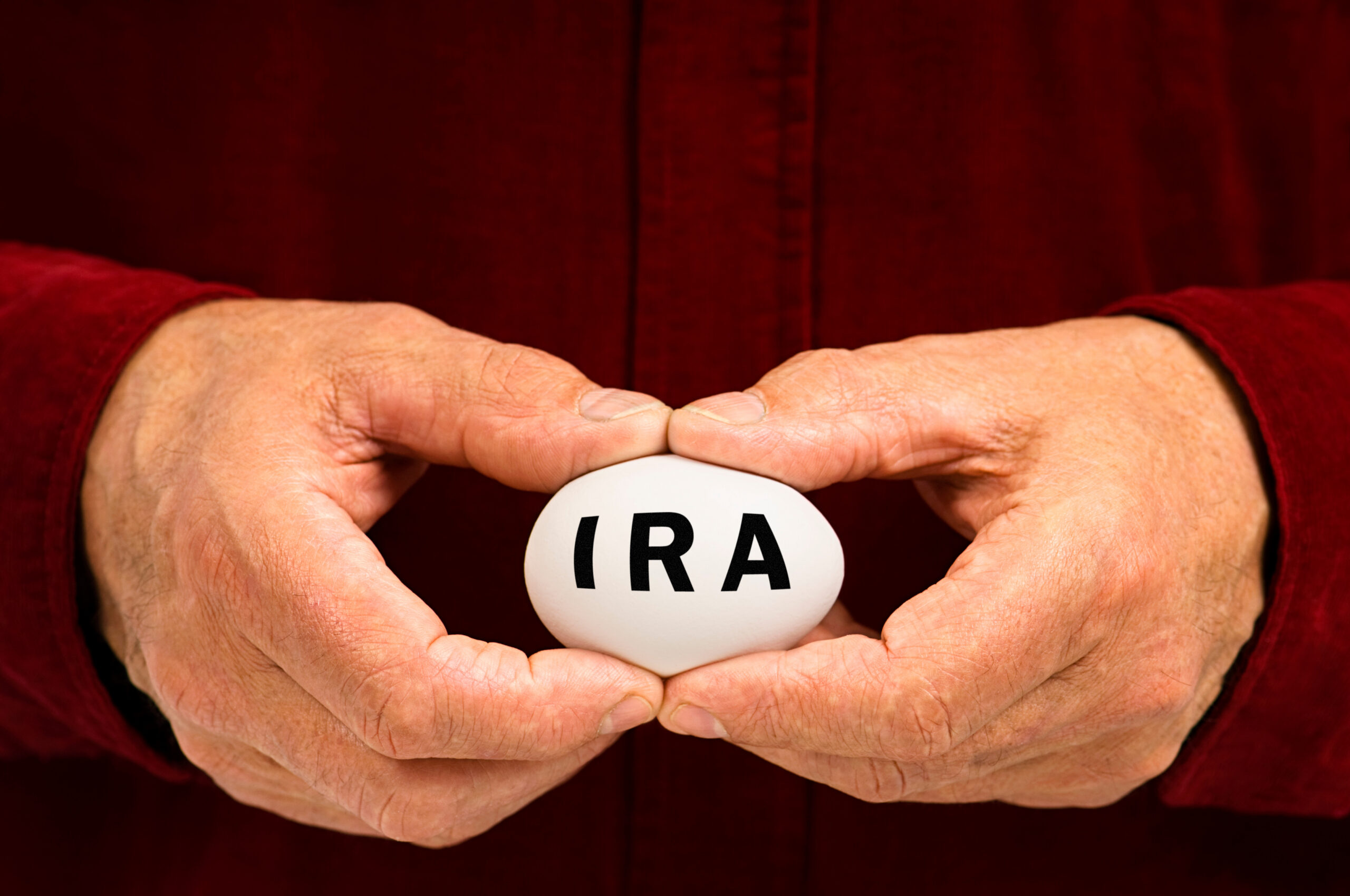 Man holds white egg with IRA written on it